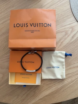 Louis Vuitton armband - Fräscht snyggt svart armband från märket Louis Vuitton. Funkar till allt och perfekt nu till sommaren när man börjar använde t shirts och vill ha lite detaljer. 