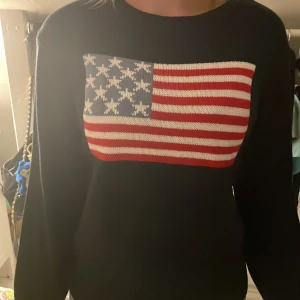 Stickad tröja - En stickad tröja med den amerikanska flaggan i mörk blå och storlek M