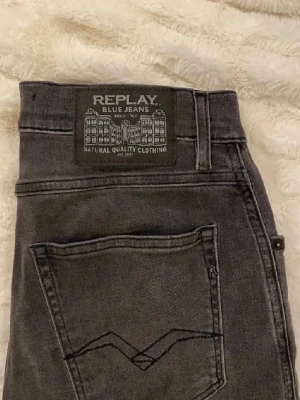 Gråa Replay jeans med smal passform - Snygga gråa jeans från Replay med smal passform och klassisk femficksdesign. Jeansen har en cool tvättad look och detaljerad bakficka med broderi. Tillverkade i slitstark denim som ger en trendig och avslappnad stil. Om ni undrar nåt skriv bara och om ni vill diskutera priset