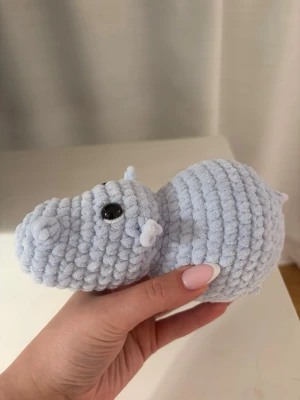 Virkad flodhäst  - Supersöt handvirkad ljusblå flodhäst/hippo!🦛 Gjord i chenillegarn med polyesterfyllning🥰 Ca 10cm x 19cm   ‼️Gosedjuret innehåller säkerhetsögon, som ej rekommenderas för barn under 3 år.