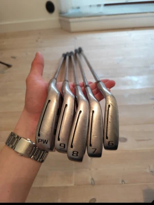 Set med fem golfklubbor järn - Säljer ett set med fem golfklubbor, järn 6, 7, 8, 9 och PW. Klubborna är i metall med svart grepp och har en stilren silverfärg. Perfekt för dig som vill komplettera din golfutrustning eller börja spela golf.