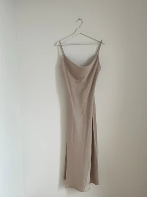Superfin beige lång satin klänning  - Gullig klänning från Shein, aldrig använd enbart testad och prislappen finns kvar. Storlek M. Finns att hämta i Göteborg men även skickas, köparen står alltid för frakt! 📦💗