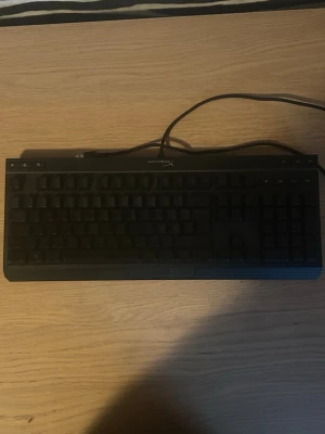 HyperX RGB tangentbord med sladd - Säljer ett HyperX tangentbord med RGB-belysning som lyser i flera färger. Tangentbordet är svart och ansluts via USB-kabel. Perfekt för gaming eller till datorn när du vill ha snygg belysning och fullstora tangenter. Tangentbordet är minimalt använd vilket man kan se en aning på knapparna. 