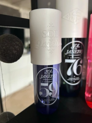 Sol de Janeiro 59 Parfymmist - Sol de Janeiro 59 är en parfymmist i en snygg lila flaska med vit kork och tydlig logga. Flaskan är gjord av plast och har en modern, stilren design. Perfekt för dig som gillar fräscha och unika dofter med en brasiliansk touch. Bara andvänds 1-2 gånger.