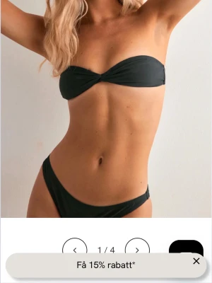 Svart bandeau bikinitopp från Nelly - Säljer en stilren svart bandeau bikini från Nelly. Överdelen har twistad detalj framtill och knyt i ryggen för justerbar passform. Beställde en för mycket så den är aldrig använd och har lapp kvar.