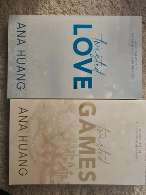 Twisted Love & Twisted Games av Ana Huang - Två böcker av Ana Huang: 'Twisted Love' med vit och blå framsida och 'Twisted Games' med vit och guld framsida. Båda har stilrena omslag med titlar i stora bokstäver och subtila mönster. Perfekt för dig som gillar romantisk skönlitteratur.