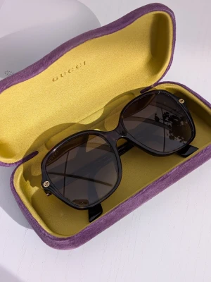 Gucci solglasögon med fodral  - Säljer mina Gucci solglasögon i väldigt fint skick. Klassisk modell i mörkbrun/tortoise färg med Gucci-logga på sidorna. ✔ Originalfodral medföljer ✔ Väldigt lite använda ✔ Inga repor på glasen Perfekta till sommaren och passar många ansiktsformer. Skickas eller kan mötas upp. Skriv gärna om du har frågor 💌