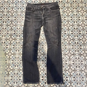 Gråa bootcut Nudie jeans vintage - Säljer ett par tvär feta vintage Nudie jeans i modellen Slim Jim! || De har snygga slitningar/hål|| De har tvär feta tiger ränder på höfterna och knäna🙌🏻|| Längd 112cm, midja 43cm, benöppning 20cm || Hör av er vid bud eller frågor!!