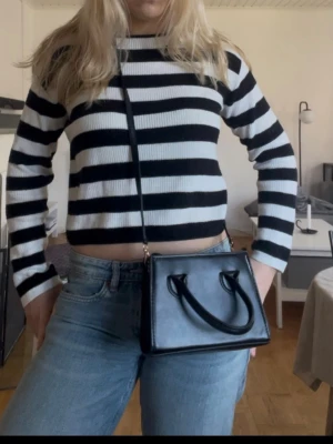 Randig svartvit croppad tröja - Trendig croppad tröja med breda svarta och vita ränder micro-ribbad struktur. Långärmad modell  med rund halsringning. Perfekt till jeans för en avslappnad frontend-stil. Stolek 170 typ M 