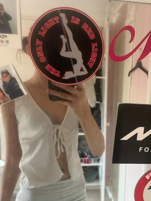 Vit linnetopp med knyt framtill - Säljer en söt vit linnetopp med knyt framtill och djup v-ringning. Toppen är ärmlös och har en lätt ribbad struktur i materialet. Perfekt för varma dagar och enkel att styla med olika outfits.