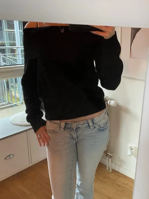 Svart off shoulder stickad tröja - Säljer en svart stickad off shoulder-tröja med långa ärmar och bred ribbad kant upptill. Aldrig använd, i storlek 158/164 men skulle säga att den sitter som S