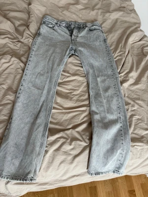 Ljusgrå hope jeans - Säljer ett par ljusgrå hope jeans med rak passform och klassisk femficksdesign. Jeansen har hög midja och råa kanter vid bensluten för en trendig look. Tillverkade i denim med en tvättad finish som ger en avslappnad vibe. Finns lite slitningar längst ner som man ser på bilden men annars i väldigt bra skick! 