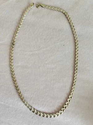 Kedjehalsband i silverfärg - Snyggt halsband med bred, platt kedja i silverfärg. Klassisk design med rundade länkar som ger ett stilrent och trendigt intryck. Perfekt för att lyfta vilken outfit som helst. Halsbandet har ett enkelt lås och känns både modernt och tidlöst.