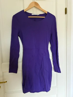 Lila långärmad klänning Ivyrevel - Snygg lila klänning från Ivyrevel med lång ärm och tight passform. Klänningen har en cool öppen ryggdetalj.