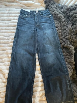 Low waist jeans från Weekday - Säljer ett par oanvända mörkblå jeans från Weekday med breda ben och låg midja i storlek 23/32. Modellen är i Ample low waist loose wide leg. Perfekta för en avslappnad och trendig look. 
