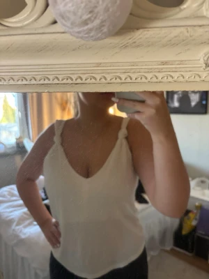 Vit ribbad linnetopp från H&M - Säljer en vit ribbad linnetopp från H&M i storlek L med smala axelband och v-ringning. Toppen är ärmlös och har en mjuk, stretchig känsla som passar perfekt till sommaren. Enkel och stilren design som är lätt att matcha💕