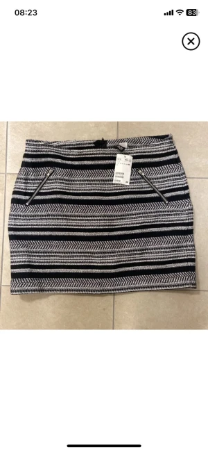 Svartvit randig kortkjol H&M - Säljer en svartvit kortkjol från H&M med horisontella ränder och dragkedjor framtill. Kjolen har en tajt passform och är gjord i ett mjukt material som känns bekvämt. Perfekt att matcha med en enkel topp för en snygg look. Ny aldrig använd