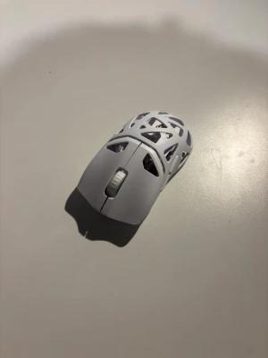 Vit ultralätt trådlös gamingmus - Säljer en vit gamingmus med unikt öppet skal i plast och geometriskt mönster. Musen har scrollhjul och två huvudknappar, perfekt för dig som vill ha en lätt och stilren mus till datorn. Passar både till gaming och vardagsanvändning. Trådlöst chip till