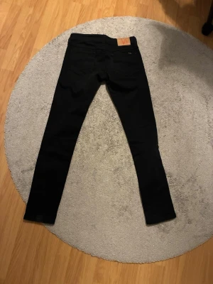 Svarta Slim Jim från Nudie Jeans - Säljer ett par svarta jeans  från Nudie Jeans, modellen Slim Jim. 