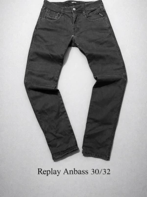 Replay Anbass svarta jeans 30/32 - Säljer ett par svarta Replay Anbass jeans i storlek 30/32. Jeansen har smal passform, klassisk femficksdesign och detaljerad bakficka med dragkedja. Tillverkade i stretchigt bomullsmaterial för extra komfort. Bra skick(lite slitna vid grenen se sista bild)ej hål