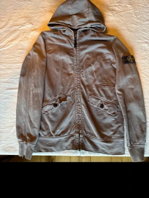 Stone Island hoodie - Säljer en snygg stone Island hoodie som är grå. Som är i storlek 156 är i relativt bra skick.