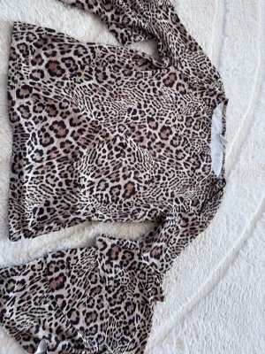 Leopardmönstrad klänning Gina Tricot - Säljer en leopardmönstrad kortklänning från Gina Tricot i storlek XS. Klänningen har långa ärmar och är tillverkad i ett mjukt, stretchigt material som sitter snyggt på kroppen. Perfekt för dig som vill sticka ut med ett djurmönster!