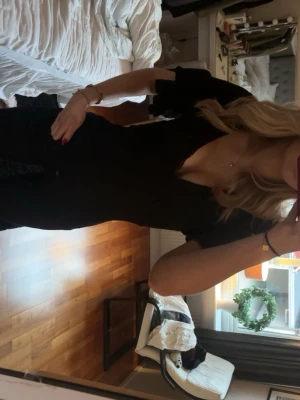 Svart v-ringad topp med volangärm - Säljer en svart topp med djup v-ringning och volangärmar. Toppen har en figurnära passform, passar till alla tillfällen!!