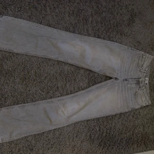 Lågmidjade Ljusblå raka jeans från 157 - Säljer ett par lågmidjade ljusblå jeans från 157 med rak passform och klassisk femficksdesign. Jeansen har en snygg tvättad look och är tillverkade i denim. Perfekta för dig som gillar en avslappnad och trendig stil.