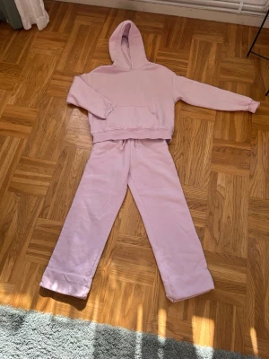 Ljusrosa mjukisset med hoodie - Säljer ett ljusrosa mjukisset med hoodie och matchande byxor från Gina tricot i storlek XS💕💕Hoodien har magficka och dragsko i huvan💕💕Byxorna har resår och dragsko i midjan💕💕I bra skick💕💕Jag säljer båda mjukis byxorna och tröjan för 100 kr tillsammans💕💕Hör av er vid intresse💕💕