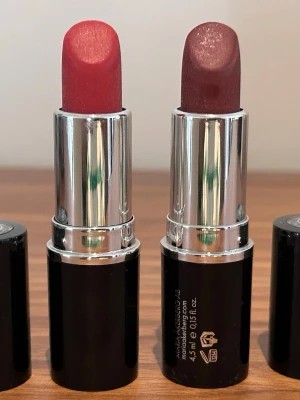 Två läppstift från Maria Åkerberg - Säljer två snygga läppstift från Maria Åkerberg. Ett i en klassisk röd nyans och ett i en mörkare, bärig ton. Färgen är halvtäckande och de är endast testade ett par gånger.