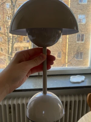 Grå bordslampa i modern design - Säljer en stilren bordslampa i grått med rundad skärm och fot. Lampan har en minimalistisk och modern form med metallmaterial och passar perfekt som inredningsdetalj. Perfekt för skrivbord eller fönsterbräda.