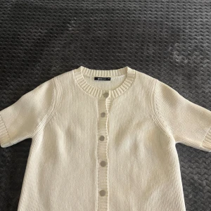 Vit stickad kofta från Gina Tricot - Säljer en krämvit stickad kofta från Gina Tricot i storlek XS. Koftan har korta ärmar, rund halsringning och knappar framtill. Använd få gånger och inga fläckar eller hål!!❣️❣️