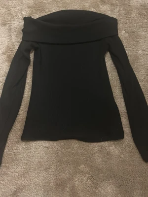 Svart offshoulder topp Gina Tricot - Trendig svart offshoulder topp från Gina Tricot i ribbad stretchig kvalitet.