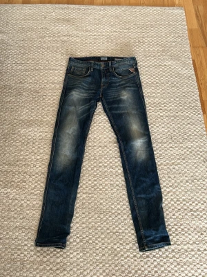 Blå slim fit jeans från replay - Säljer ett par blå slim fit jeans från replay med snygga slitningar och tvättade detaljer. Replay anbass original replay blue jeans. Gott skick. Storlek w29 l 32