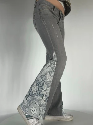 Old School Lace  - Här är våra ”Old School Lace” jeans i storlek XS Mått: 33 cm rakt över midjan & 70 cm i innerbenslängd.