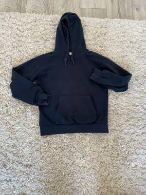 Mörkblå hoodie med magficka - Säljer en oversized hoodie från Gina tricot. Hoodien är mörkblå med två snören där fram och även en magficka. 