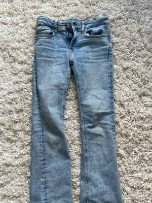 Ljusblå bootcut jeans från Calvin Klein  - Säljer ett par ljusblå bootcut jeans med klassisk femficksdesign och normalhög midja från Calvin Klein. Jeansen har en snygg tvättad look och är tillverkade i mjukt denimtyg. 