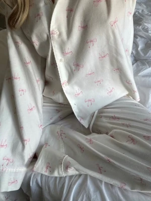 Vit pyjamas med rosa rosetter Gina tricot - Byxor: xs tröja:s ej använd endast tvättat