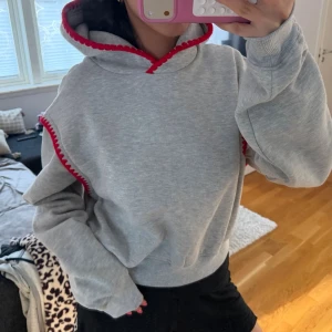 Grå Hoodie med röda detaljer  - Skit snygg hoodie som passar bra på mig som brukar bära S! Ny med lapp kvar.  