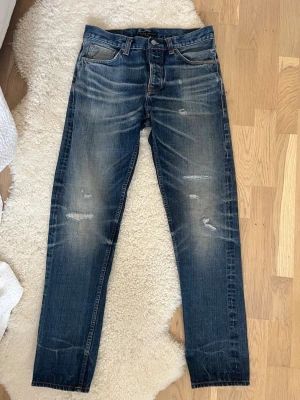 Nudie Jeans Steady Eddie Selvage Lab  - Loose-fit nudies limiterade till 110 exemplar världen över. Detta exemplar är resultatet av både genuint denim hantverk och en intensiv tvätt process ledd av ett specialist team i nudies denimlabb. Strlk 32/34