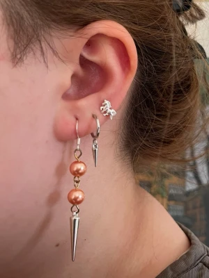 Orangea handgjorda pärlörhängen med nitar  - Jag skapar dessa örhängen av noggrant utvalda pärlor från secondhand – ett medvetet val för att ge vackra material ett nytt liv. Alla örhängen är handgjorda och säljs i par 💖🫶🏻⚜️. Dessa örhängen har (metallen från de) en mörkare yta och är därför benämnda som acceptabelt skick🧡