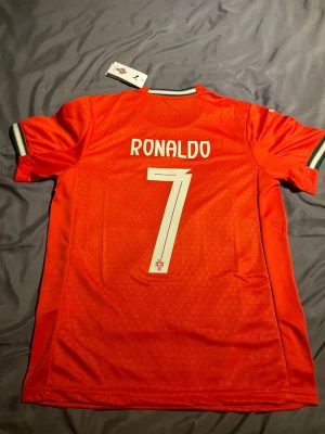 Portugal Ronaldo matchtröja Puma - Snygg röd Portugal matchtröja med cristiano ronaldo på ryggen. Skick 10/10 fraktas mellan 1-2 dagar efter köp.