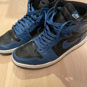 Nike Air Jordans i blått och svart - Snygga Nike Air Jordans i en cool kombination av blått och svart. Skorna har klassisk snörning och är tillverkade i skinn. Perfekta för dig som vill ha en stilren och sportig look. Har inte box till skorna, samt att ”originala” sulan inte är i. Eftersom jag har inlägg i mina skor.   Har ni funderingar/frågor så skriv!👍