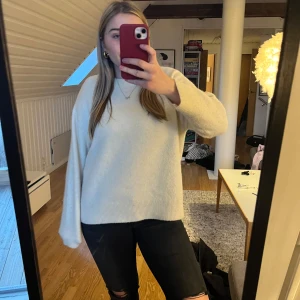 Vit stickad tröja - Säljer en mysig vit stickad tröja med långa ärmar. Perfekt för kyliga dagar och enkel att matcha med olika outfits. Tröjan har en avslappnad passform och ribbade kanter vid ärmslut och nederkant.