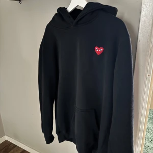 Cdg hoodie  - En cdg hoodie som är i ett okej skick. Storlek på tröjan är XXL men sitter som en M-L.  Det är bara att skriva om du vill se bild med den på eller någon annan fråga eller fundering💫👍 nypris på den  är runt 2500kr