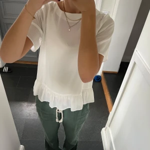 Vit volangtopp - Vit kortärmad volangblus från ASOS i storlek 38, passar S och M. Fint skick. Lite genomskinlig. Använd gärna köp nu!