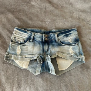 Blå jeansshorts med slitningar - Super snygga lågmidjade jeansshorts med slitna detaljer. Står tyvärr inte vilket märke. Säljer då de inte passar mig längre💗