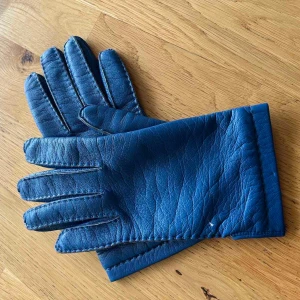 Blå skinnhandskar - Snygga blå skinnhandskar med klassisk design. Perfekta för att hålla händerna varma och stiliga under kyliga dagar. De har en mjuk insida och är sydda med noggranna detaljer för en bekväm passform.