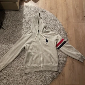 Ralph Lauren Hoodie - Grå Ralph Lauren sip up. Använt några få gånger bara. Storleken är XL men sitter mer som en L.