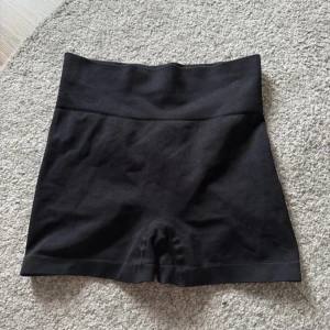 Svarta högmidjade shorts - Snygga svarta shorts med hög midja och tight passform. Perfekta för träning eller en avslappnad dag. Tillverkade i ett stretchigt material som ger bra stöd och komfort.